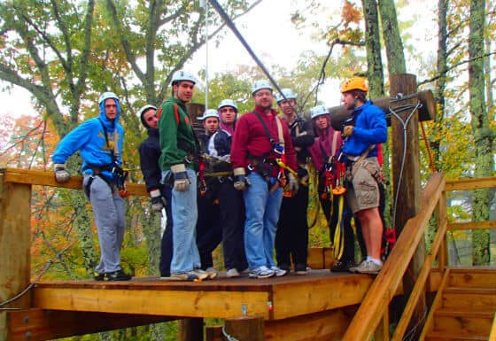 men zip lining in adventure therapy for addiction recovery