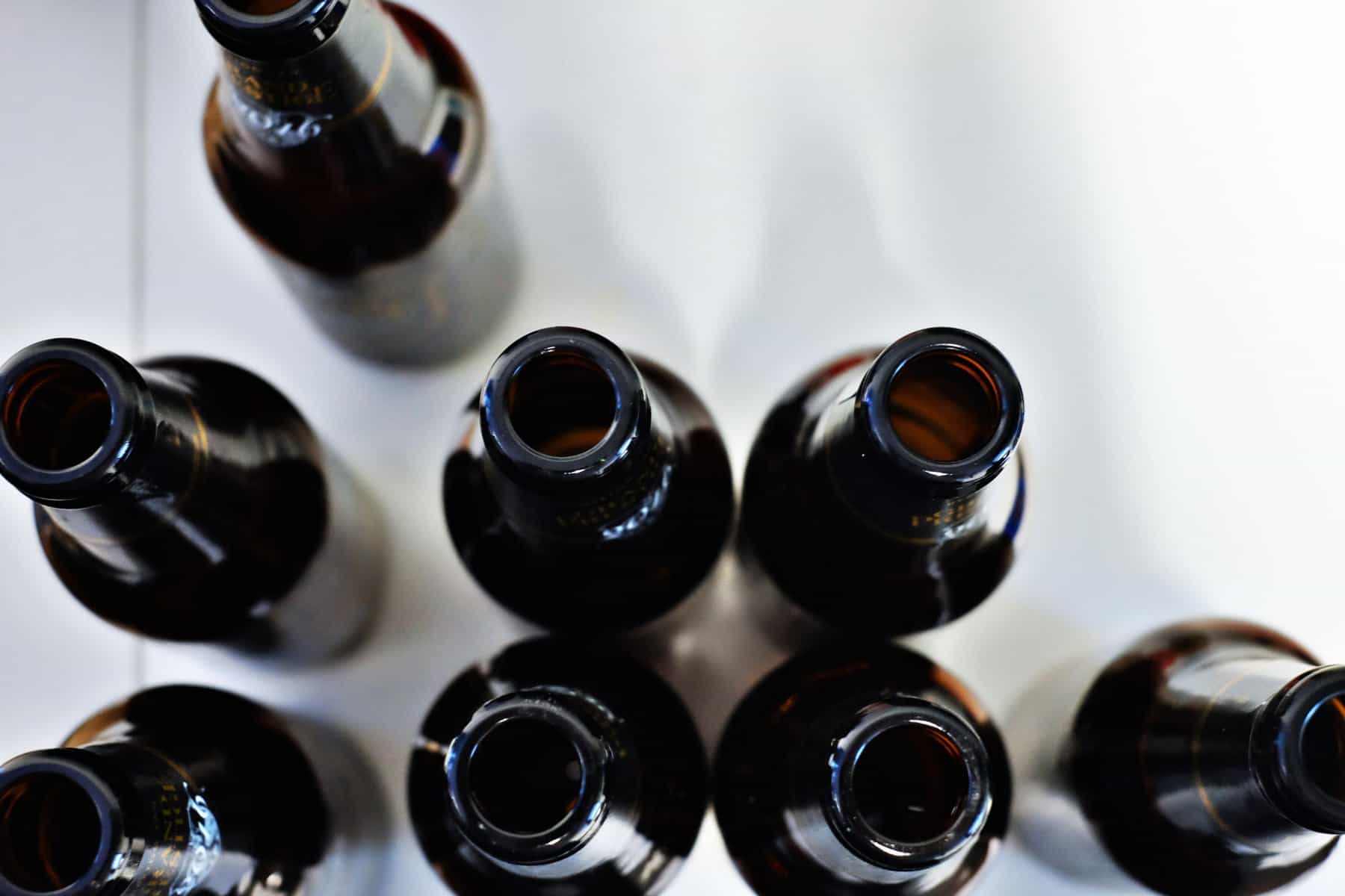 An aerial view of beer bottles on a white table represents the decision to pursue alcoholism treatment in Asheville.